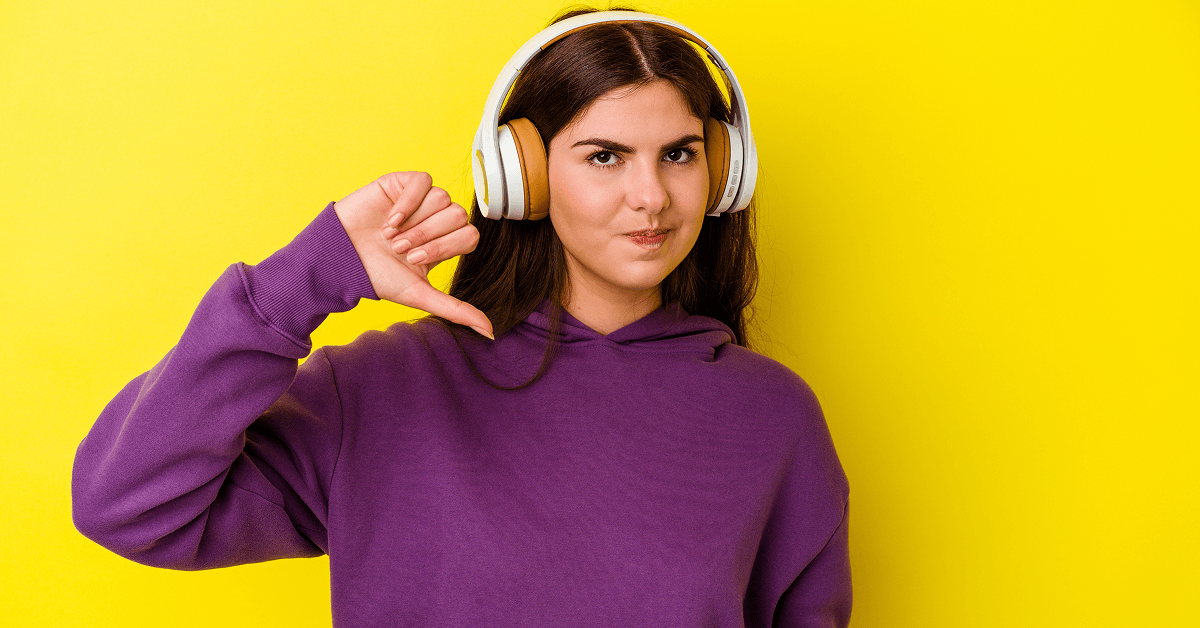 Woman wearing headphones giving a "thumbs down" gesture.